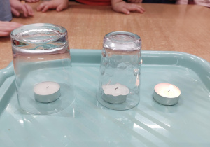 dzieci obserwują gasnące trzy świeczki